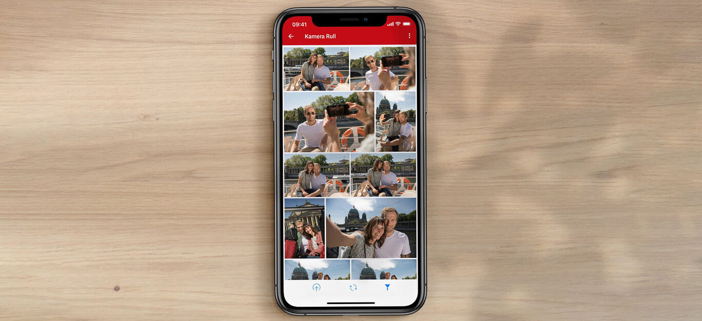 En smartphone skærm viser forskellige billeder af glade mennesker på en solrig dag.