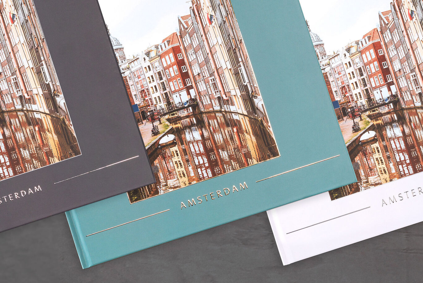 Tre fotoalbum med Amsterdam bybilleder på en mørk baggrund.